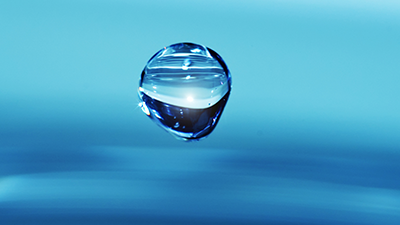 Singular rain drop with blue background